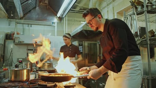 Chef Using Blow Torch and Cooking Food in Fire Flames in Restaurant Kitchen