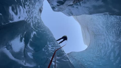 Un grimpeur dévale un moulin glaciaire.
