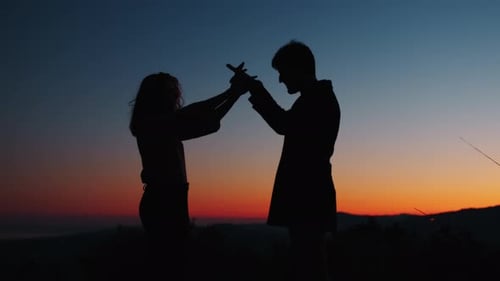 Silhouette Couple Holding Hands at Sunset