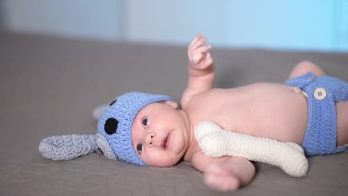 Adorable Infant Lying on Gray Quilted Surface
