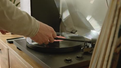 Hands Placing Vinyl Record on Record Player