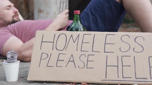 Homeless man with a sign please help dreams of his own house. Concept of unemployment and crisis.