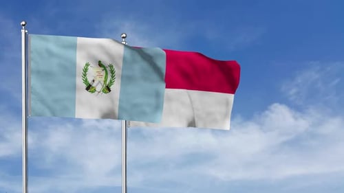 Waving Flags of Guatemala and Indonesia on Blue Sky