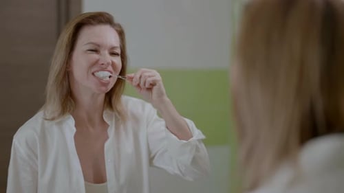 Woman Brushing Teeth in Bathroom, Morning Routine