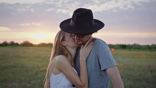 Couple Kissing at Sunset in Meadow