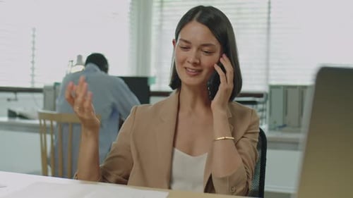 Businesswoman Talking on Phone during Office Workday