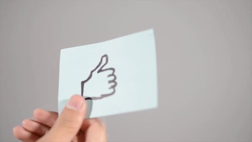 Hand Draws Thumbs Up on Paper Close Up