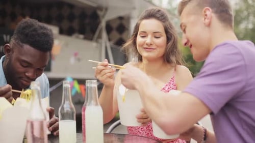 Friends Enjoying Takeout Noodles at Food Truck