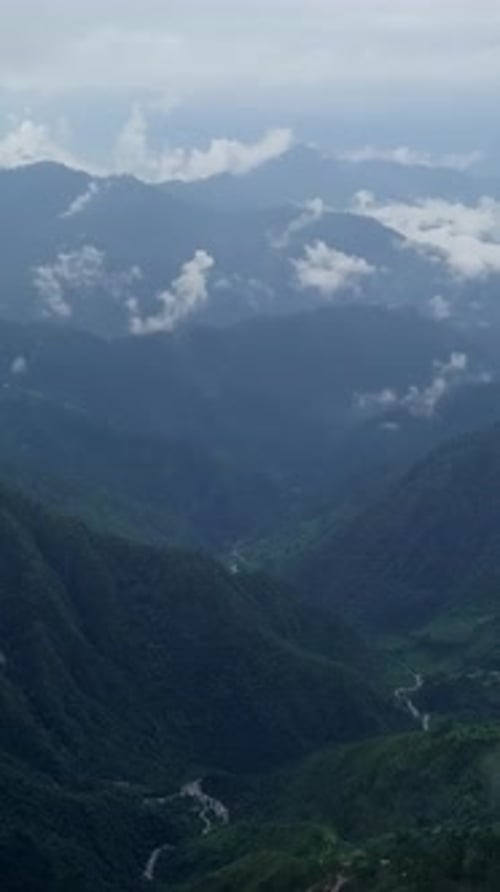 A Serene and Stunning Mountain Landscape Featuring Fog and Clouds Above the Horizon Stock Clip