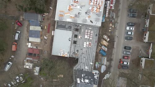 Luftbild von oben nach unten, wie ein Bauarbeiter unter einer großen Baustelle arbeitet — Drohne beim Absetzen