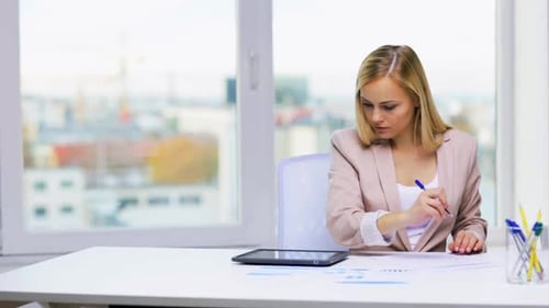 Businesswoman works with tablet and papers for education and technology concept