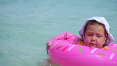 Linda menina flutuando com anel inflável no mar