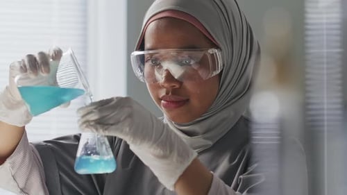 Female Scientist Experimenting with Blue Liquid in Lab