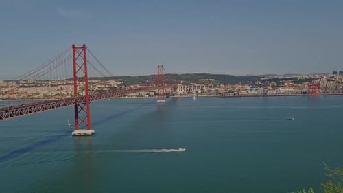 Panoramic view of the 25th April Bridge on a bright and sunny day in Lisbon, Portugal