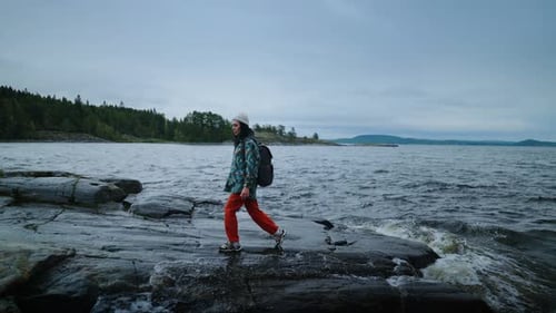 Young Adult Hiking on Rocky Beach Near Sea