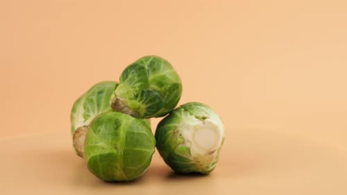 Brussels sprouts rotate on an orange background.
