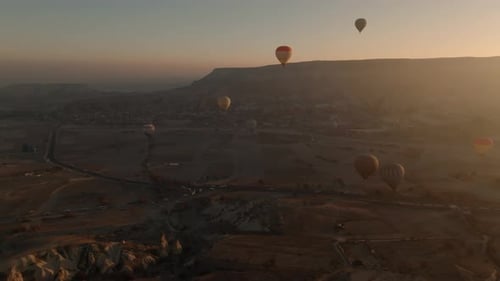 Drone view of hundreds of colorful hot air balloons soaring at sunrise in Cappadocia