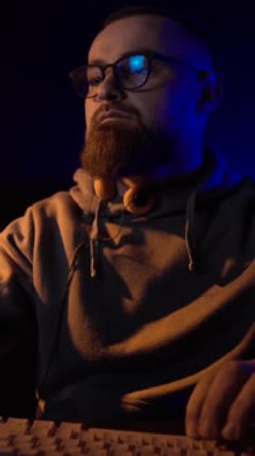 Vertical View of Computer Expert From Working in Front of Monitor Screen in Dark Room