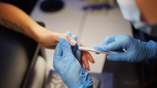 Manicurist Filing Acrylic Nails at a Nail Salon