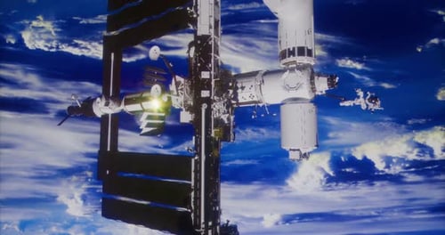 ISS orbita a Terra com painéis solares estendidos em céu azul claro