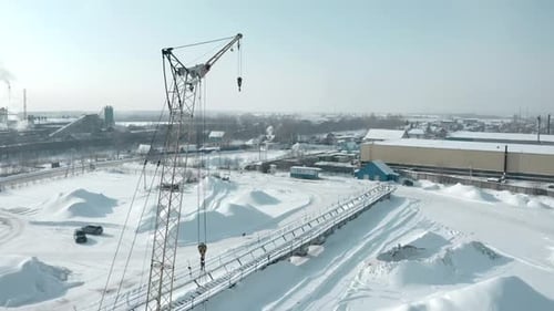 Kranheben über verschneitem Industriegelände im Winter