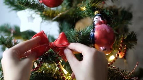 Decorating a Christmas Tree with a Red Bow