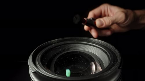 Lens Cleaning with Brush on Black Background