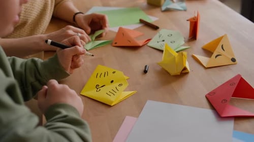 People Make Origami at Wooden Table