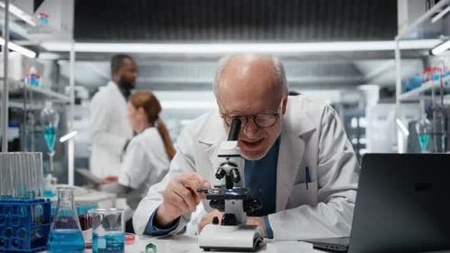 Senior Man Using Microscope in Modern Laboratory