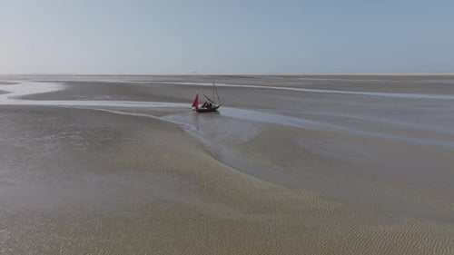 Small sailing boat in tidal channel