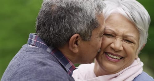Love, happy and senior couple kiss in park for date, fun and travel, bond
