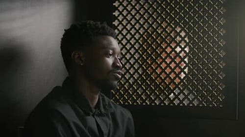 Young Black Parishioner Talking with Priest in Confessional Booth