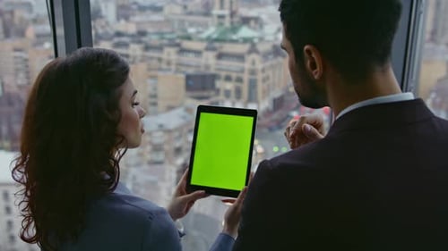 Successful Business Couple Looking Green Screen Tablet at Office Window Close Up