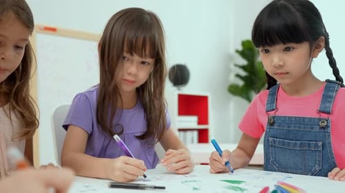 Young Children Drawing Together at Table in Classroom