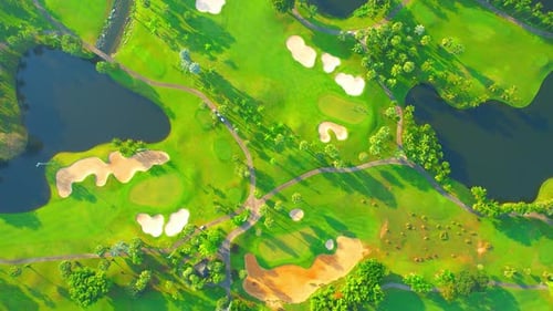 Aerial view over golf field landscape during sunrise