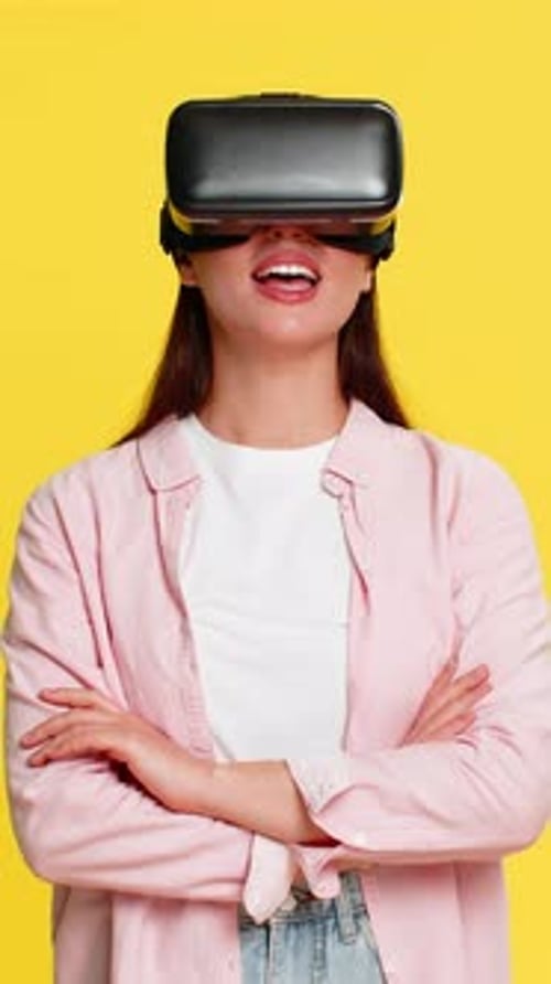 Young Woman Using Virtual Reality Headset on Yellow Background
