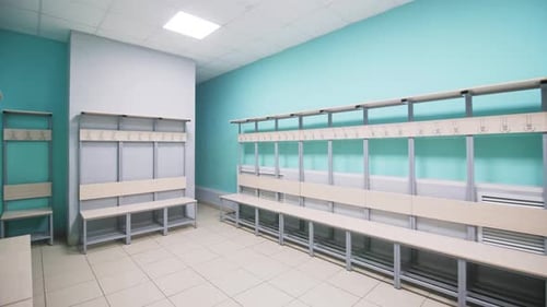 Bancos de madera con perchas en el vestuario vacío del gimnasio