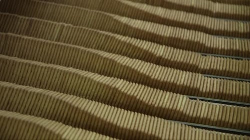 lot of square cookies are pressed together on conveyor line before being packed