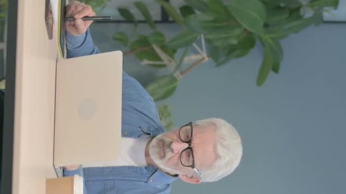 Senior Man Working with Graphic Tablet and Laptop