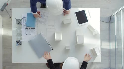 Architectural Planning Overhead View of Design Team Reviewing Blueprints