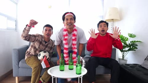 Excited Young Men Watch Sports Indoors and Celebrate