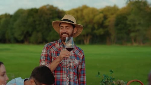 Friends Enjoying Picnic Outdoors on a Grassy Field
