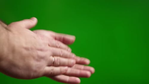 15a. A man claps his hands on a green background.