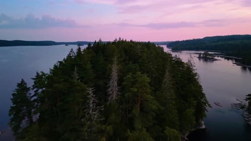 Aerial sunset of forested island, Hällingsjö, Sweden