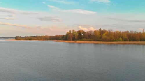 Approaching Jugla lake shores Riga at golden hour aerial