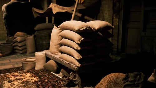 Flickering Light on Rustic Sacks in a Dark Merchant Room