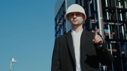 Man with Hard Hat Making Hand Gesture Outdoors