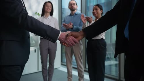 Business Handshake in Modern Office with Team