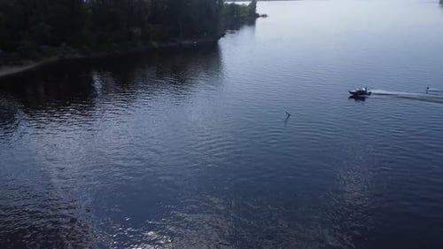 A Young Man Rides a Wakeboard A Sports Guy Rides on the Water on a Board Behind a Boat Top View From