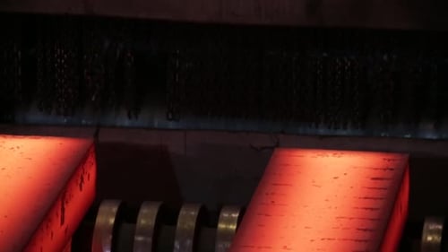 Close-up of glowing hot metal in an industrial steel mill, showcasing the intense heat and